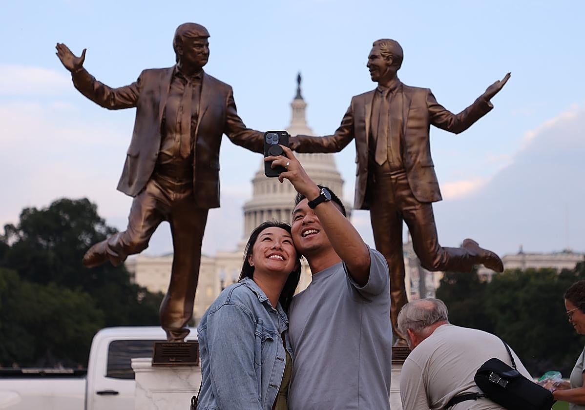 Dos personas se fotografían frente a la novedosa estatua de Trump y Epstein en Washington D.C.