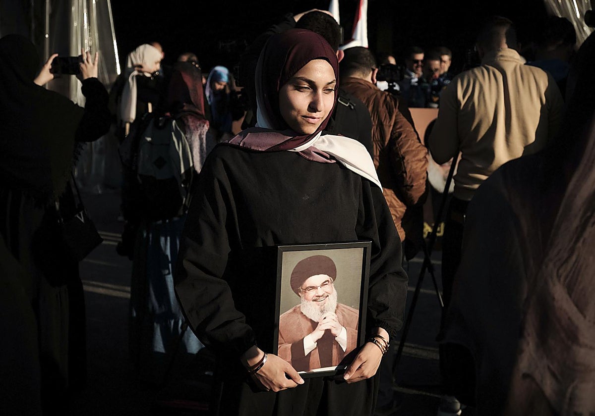 Una mujer sostiene un retrato del fallecido líder de Hizbulá, Hasán Nasrala, a las afueras del mausoleo donde descansan sus restos