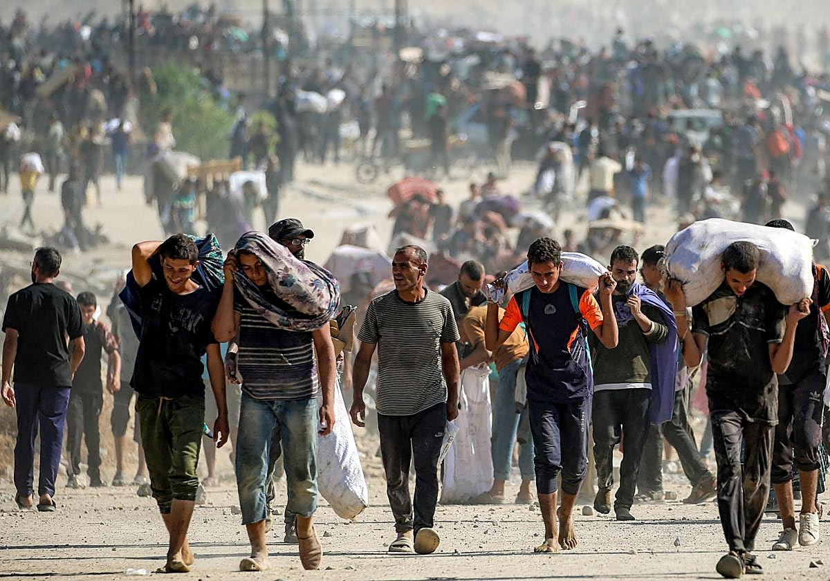 Un grupo de hombres carga con ayuda humanitaria recogida en un centro de distribución en Gaza