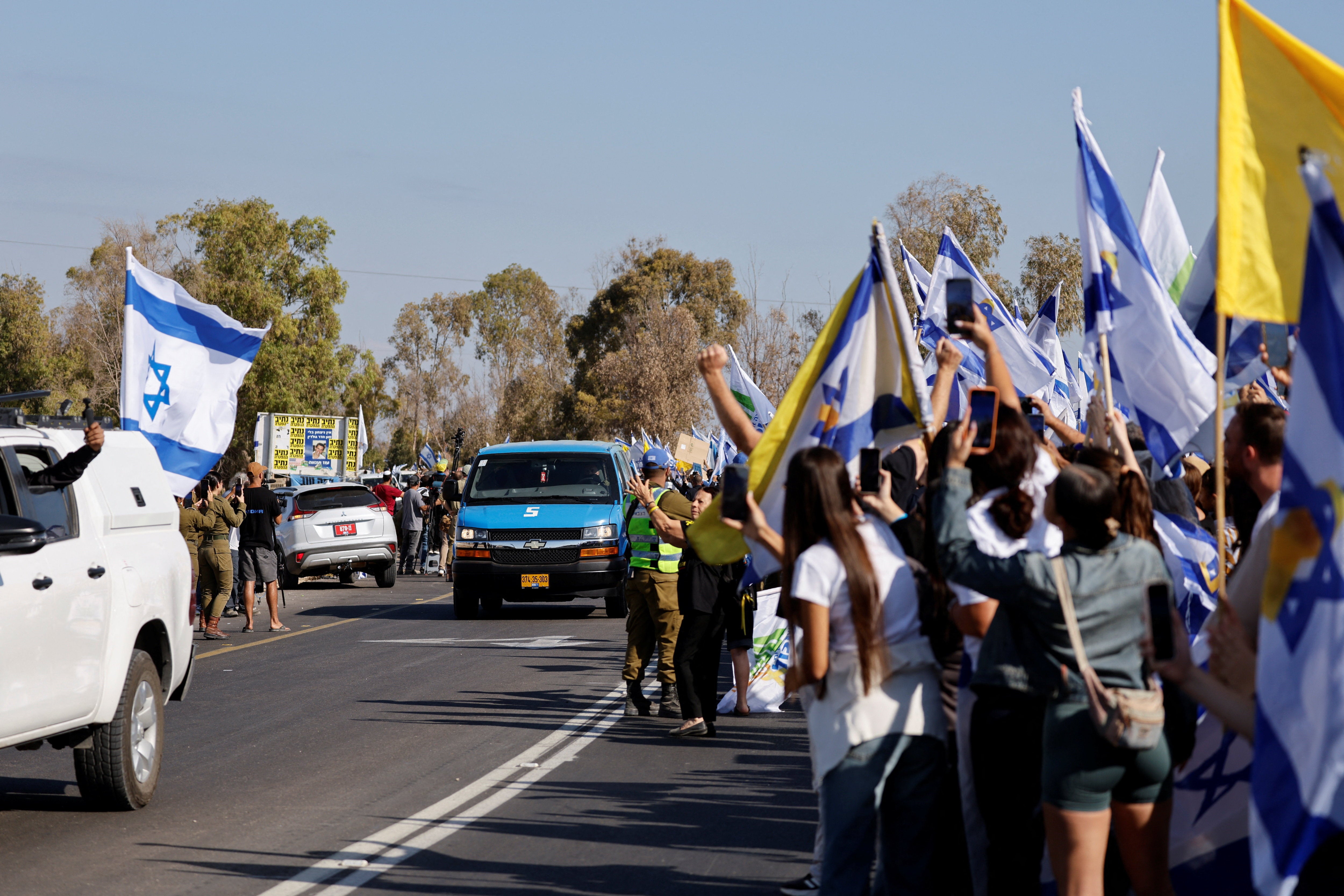 Multitudes de personas esperan el paso de los rehenes que han sido liberados. 