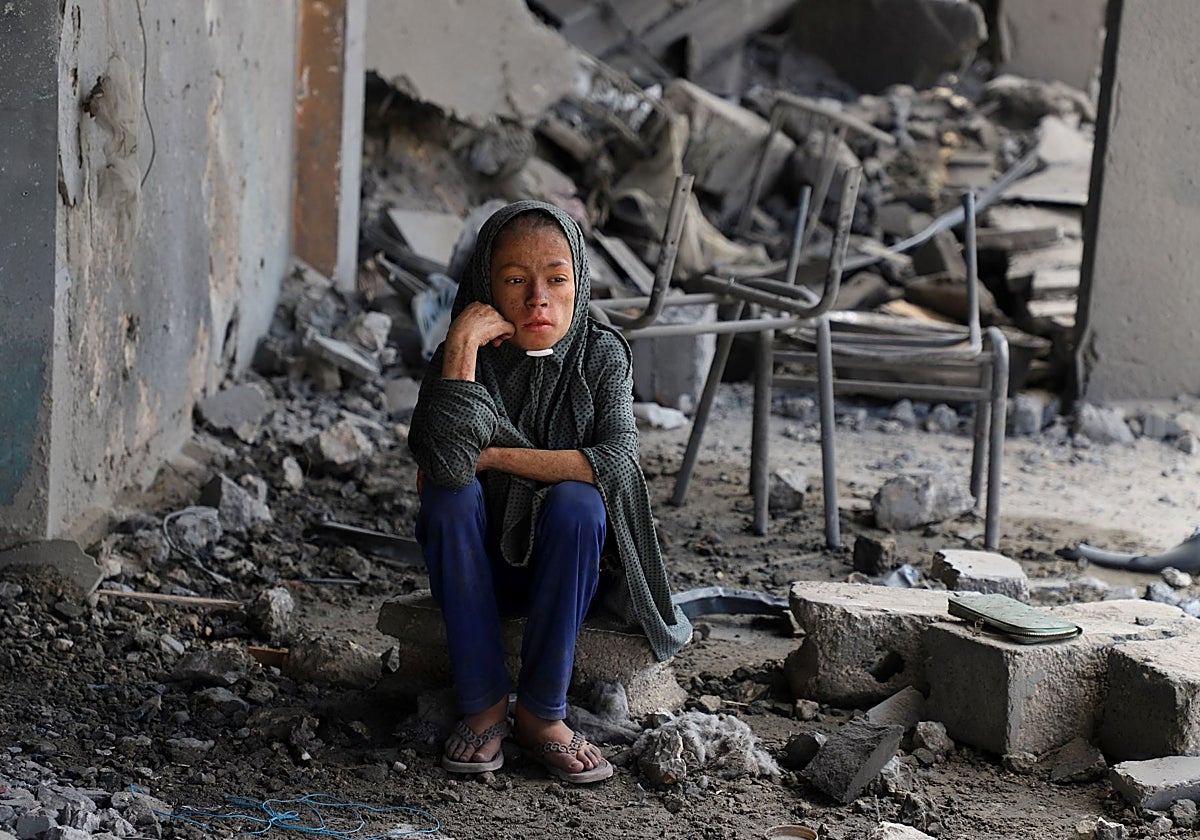 Una niña palestina entre los escombros de una escuela de la ONU bombardeada durante una ofensiva israelí en Ciudad de Gaza