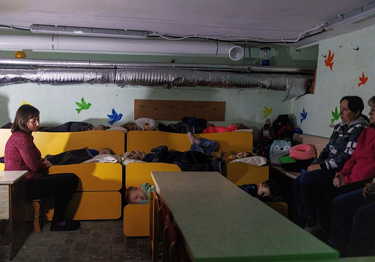 Empleados de guardería cuidan de unos niños en un refugio durante una alerta en Chernígov
