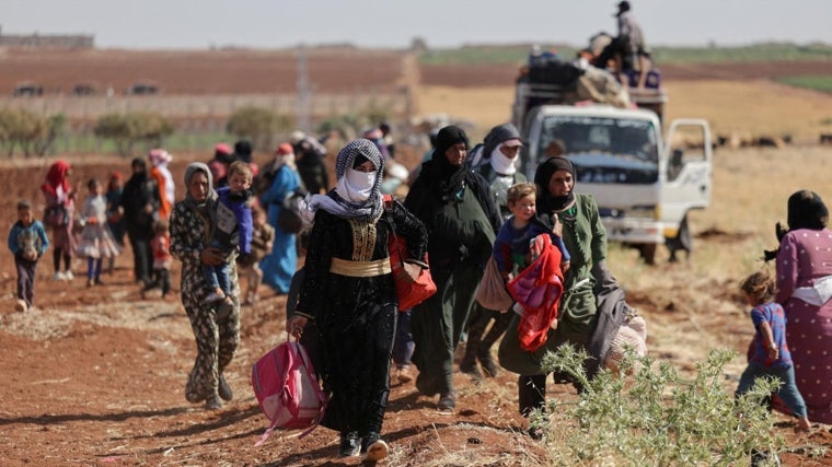Población desplzada que camina por los caminos de Sueida tras los conflictos de julio