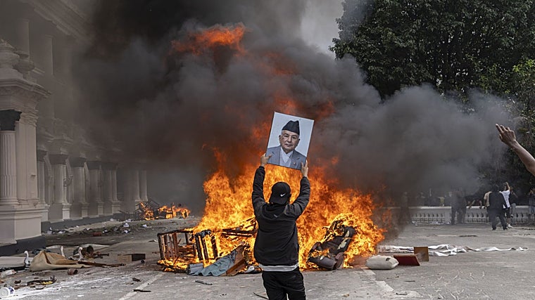 Un joven se dispone a quemar el retrato de K. P. Sharma Oli