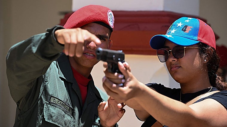 Un miembro de la Guardia Presidencial instruye a un recluta de la Milicia Nacional Bolivariana en el manejo de armas durante un ejercicio de entrenamiento