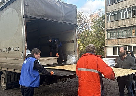 Imagen secundaria 1 - En la primera imagen, una furgoneta calcinada tras el impacto de un misil Iskander; en la segunda, los voluntarios reparten tablones de contrachapado para cubrir ventanas en las casas afectadas; y, en la tercera, una casa afectada por el impacto de un dron ruso