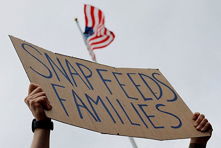 Un hombre sostiene un cartel que dice «SNAP alimenta a las familias», durante una protesta