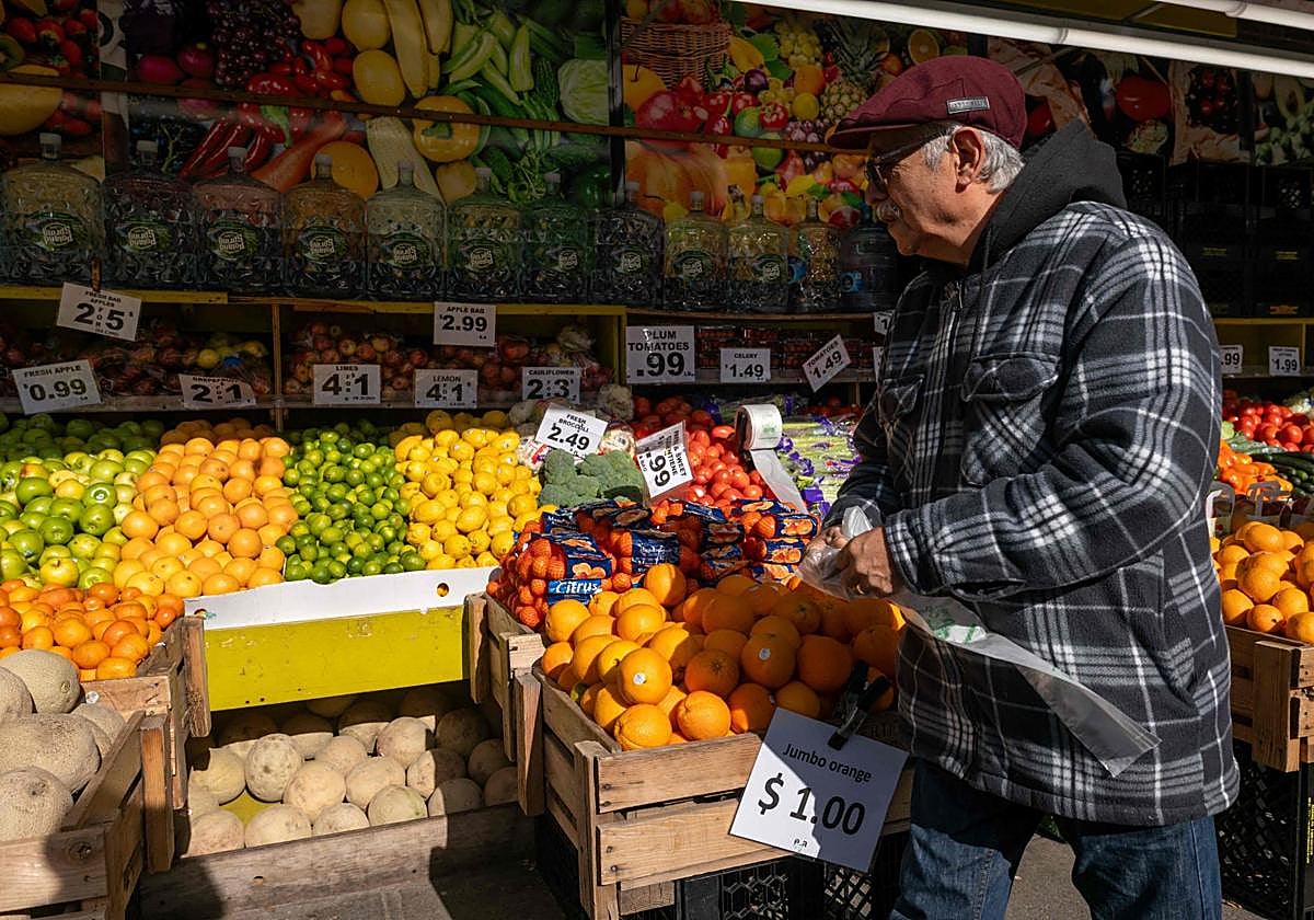 Un hombre compra fruta en una tienda del distrito de Brooklyn