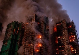 El humo y las llamas se elevan mientras un gran incendio envuelve varios edificios residenciales en Hong Kong