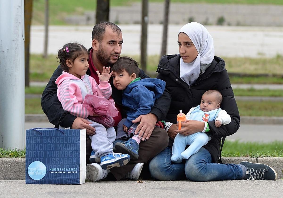 Una familia de refugiados sirios espera frente a un refugio provisional para inmigrantes tras su llegada a Múnich