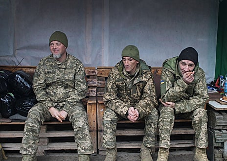 Segunda Imagem 1 - Um drone sobrevoa um grupo de recrutas da 65ª Brigada durante o treinamento (primeira imagem). A chegada deles coincide com o retorno dos soldados que voltam do front, como Jrap, Japones e Burik, que aproveitam para descansar (segunda imagem). Alguns recrutas, como Abuelo, têm 51 anos (terceira imagem).