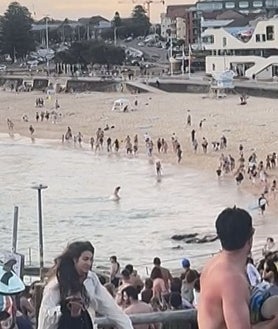Imagen secundaria 2 - Arriba, vista aérea del personal de emergencias trabajando en la escena del tiroteo en Bondi Beach en Sídney, Australia, el 14 de diciembre de 2025. Abajo, izquierda, homenaje en memoria de los fallecidos en Tel Aviv, judíos que celebraban una fiesta en la playa. A la derecha, captura del momento de la irrupción de varios atacantes en el arenal australiano y cómo cunde el pánico entre los presentes