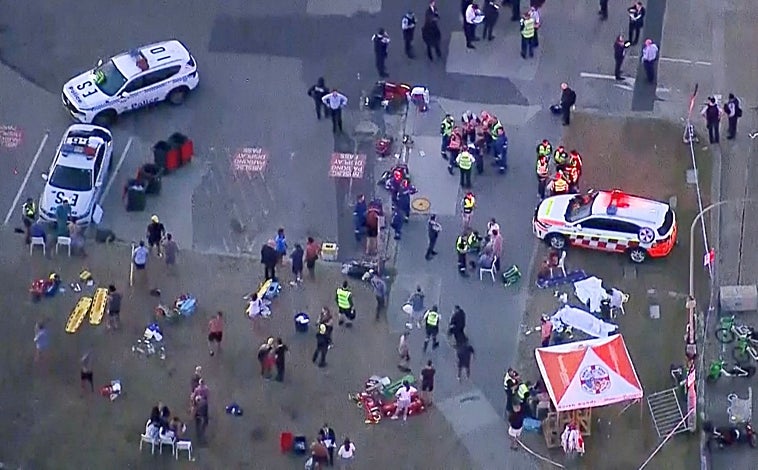 Imagen principal - Arriba, vista aérea del personal de emergencias trabajando en la escena del tiroteo en Bondi Beach en Sídney, Australia, el 14 de diciembre de 2025. Abajo, izquierda, homenaje en memoria de los fallecidos en Tel Aviv, judíos que celebraban una fiesta en la playa. A la derecha, captura del momento de la irrupción de varios atacantes en el arenal australiano y cómo cunde el pánico entre los presentes