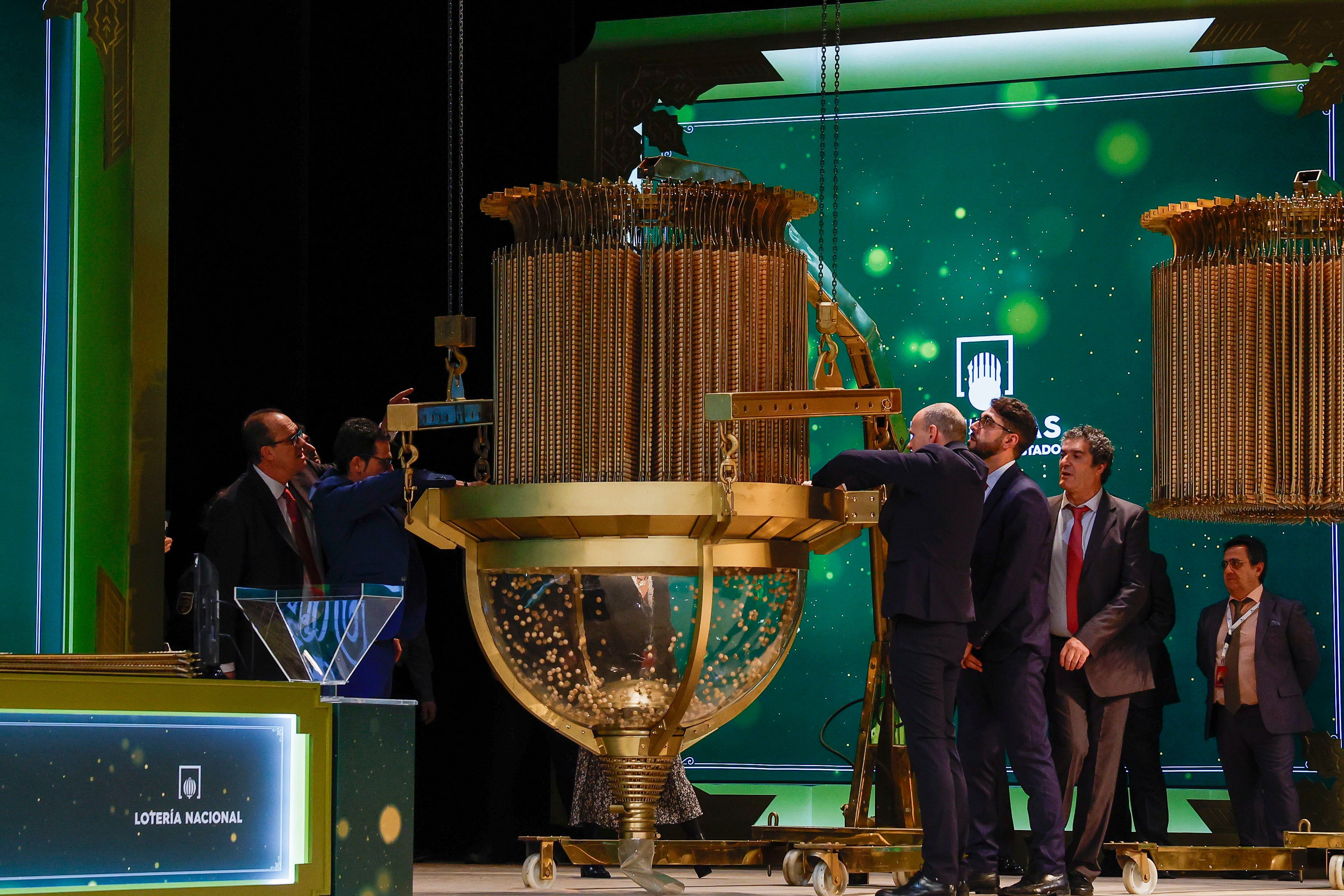 Varios operarios ultiman los detalles del bombo en el Teatro Real de Madrid durante el sorteo extraordinario de Navidad.