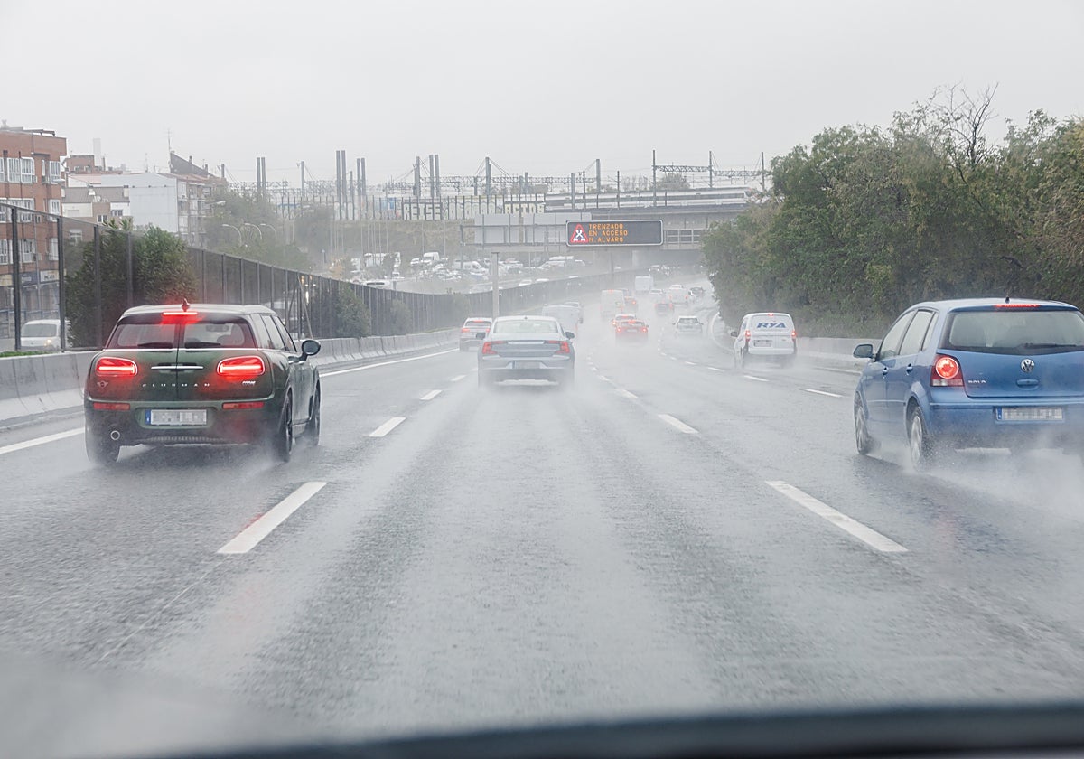 Imagen de varios coches circulando bajo la lluvia