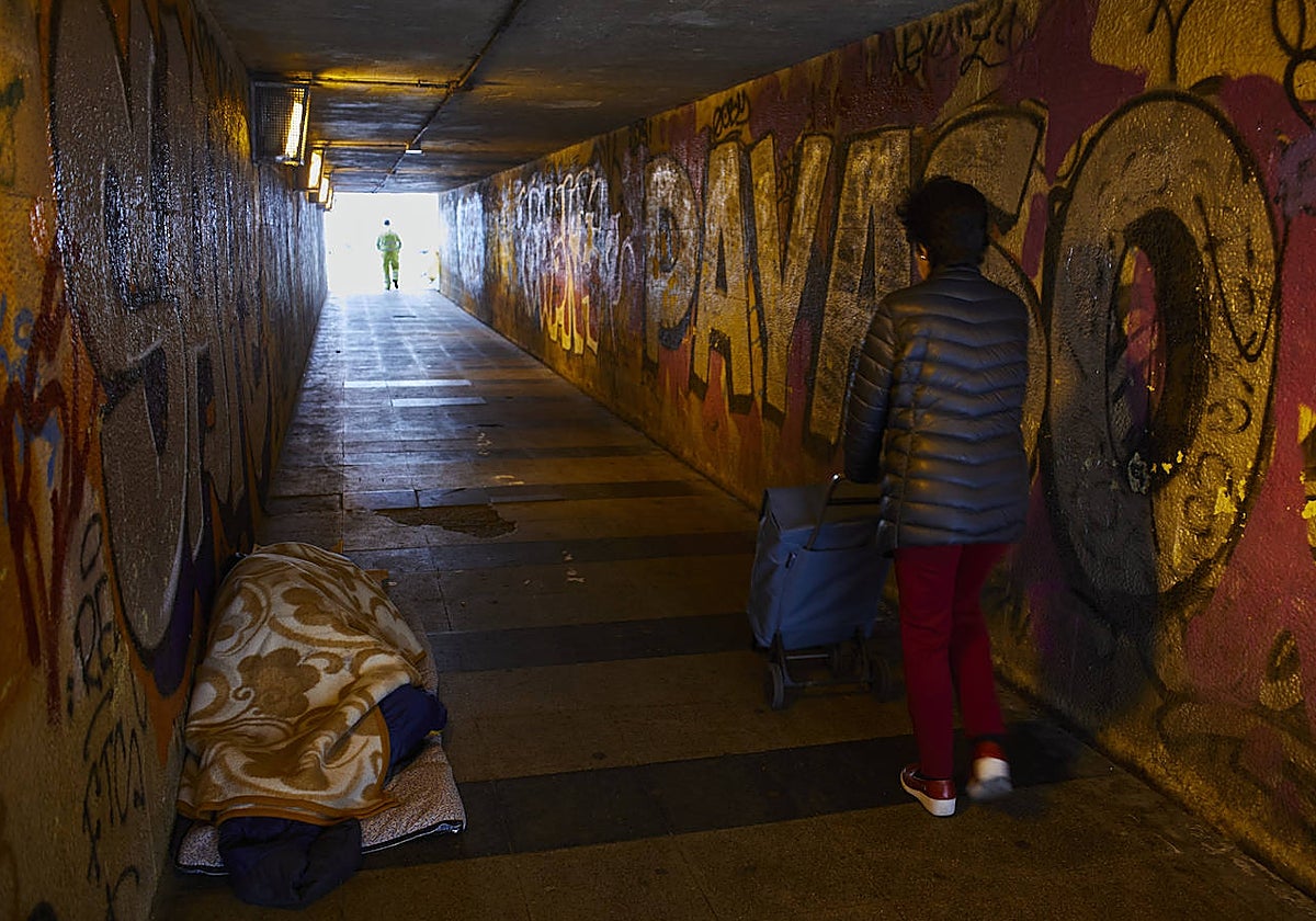 Una persona sin hogar duerme en el paso inferior de la calle de Villavieja