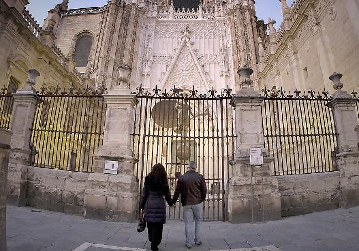 Una pareja ante la estatua del Giraldillo en la Catedral