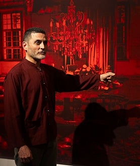 Imagen secundaria 2 - Arriba, el pintor acaricia a su perro Metta, protagonista de su políptico. Sobre estas líneas, Garcerá frente a su inmensa biblioteca. A la derecha, explicando la pieza