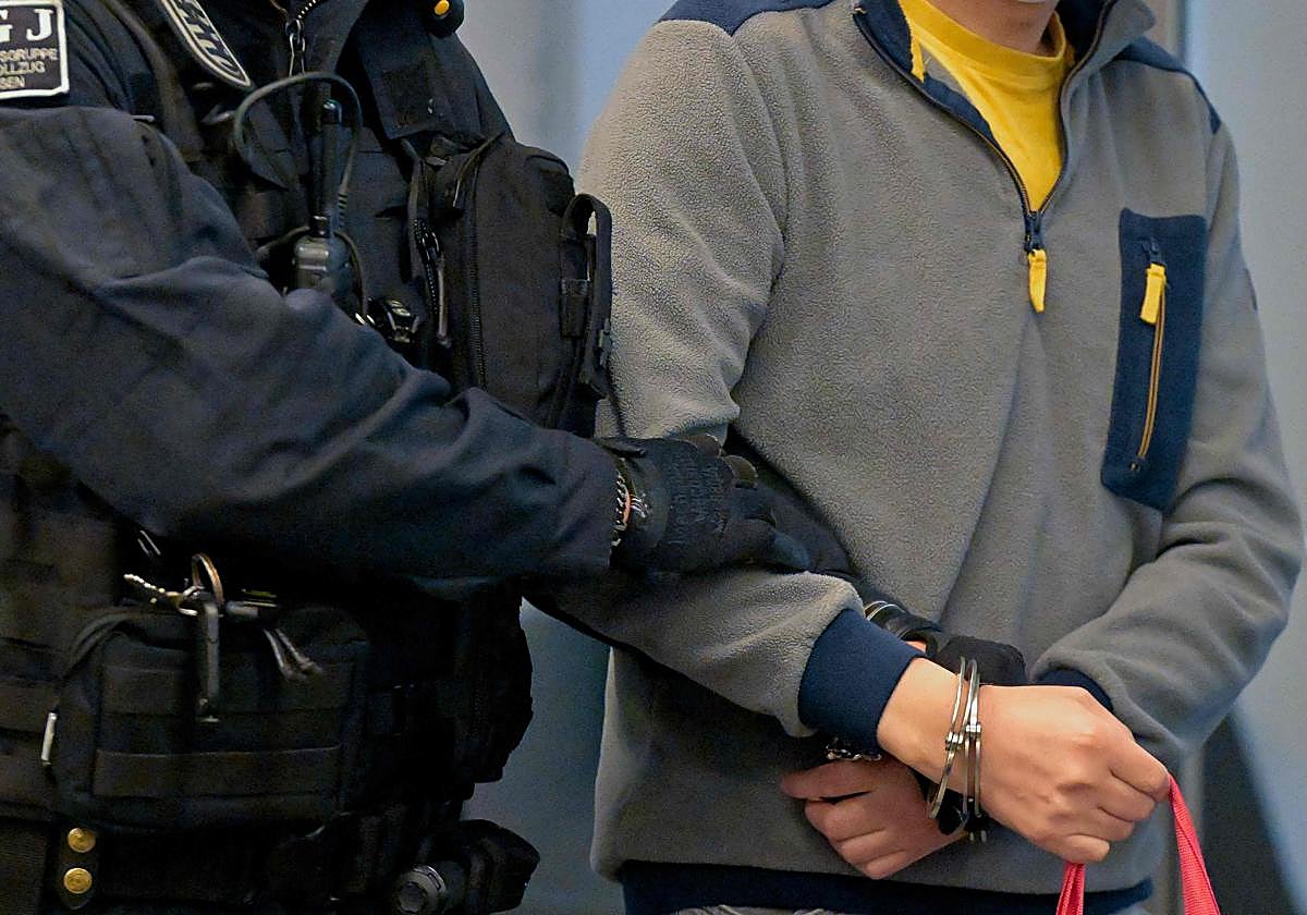 Jian G. llega esposado a la sala del tribunal para el juicio