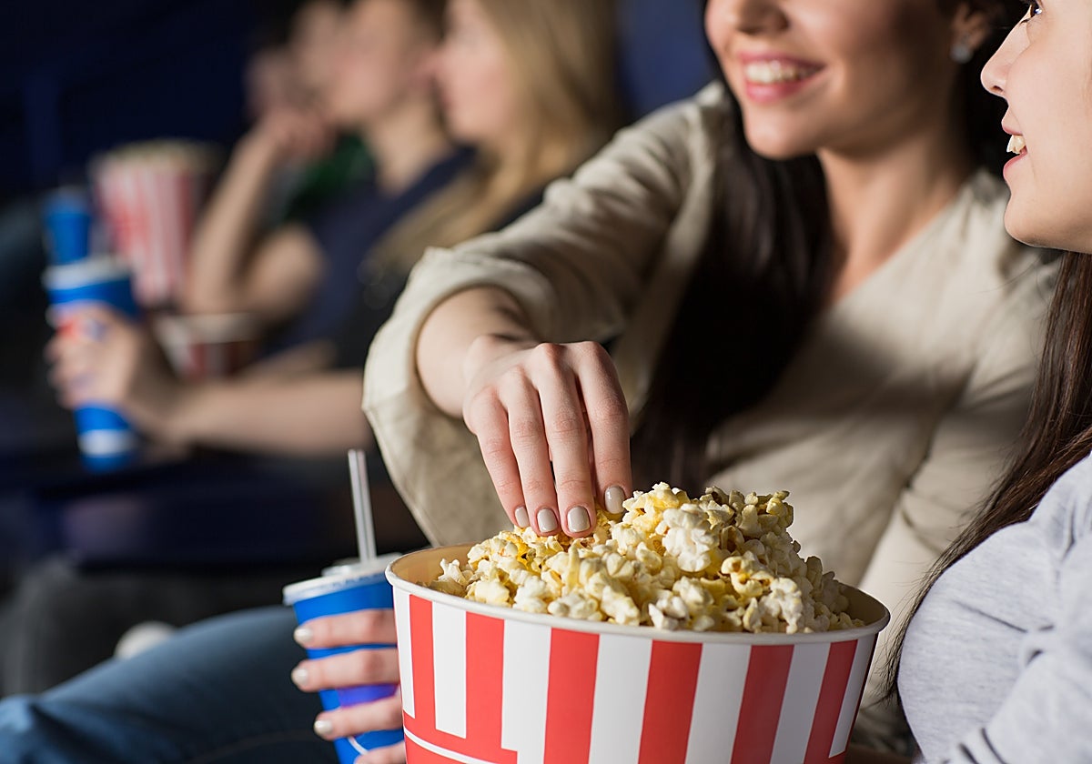 Fotografía de dos personas viendo una película en el cine