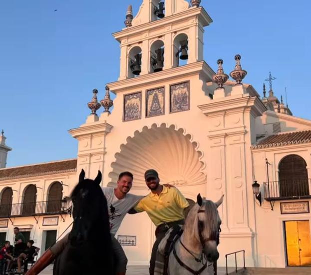 Maluma junto a su instructor de equitación en la puerta de la Ermita de la Virgen del Rocío