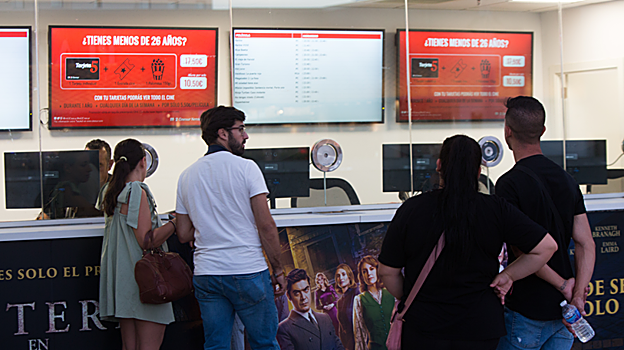 Varias personas en la taquilla de un cine en Sevilla