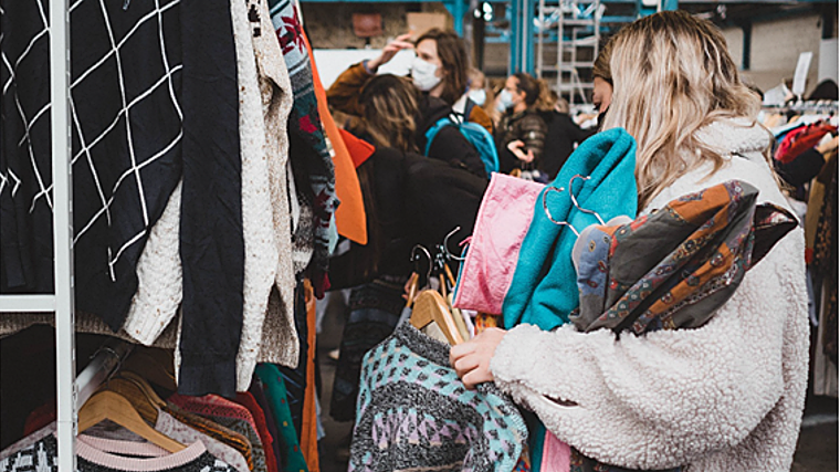 Imagen de una persona cargada de ropa en el mercadillo Rethink Vintage