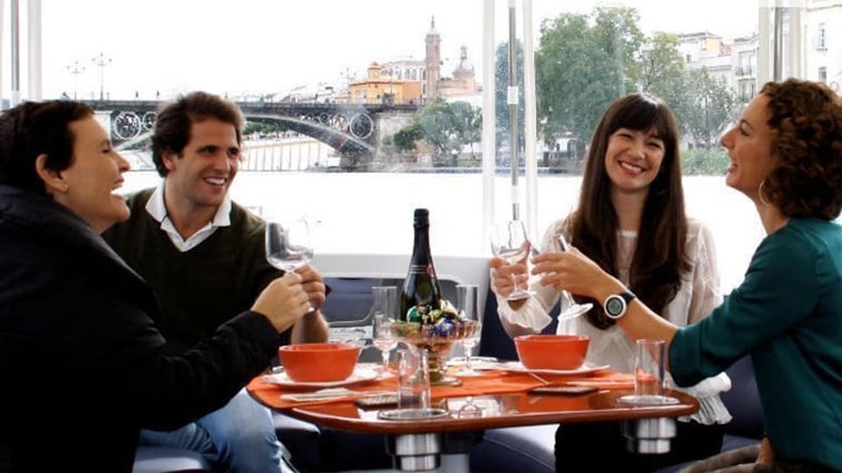 Un grupo de amigos paseando en barco por el Guadalquivir