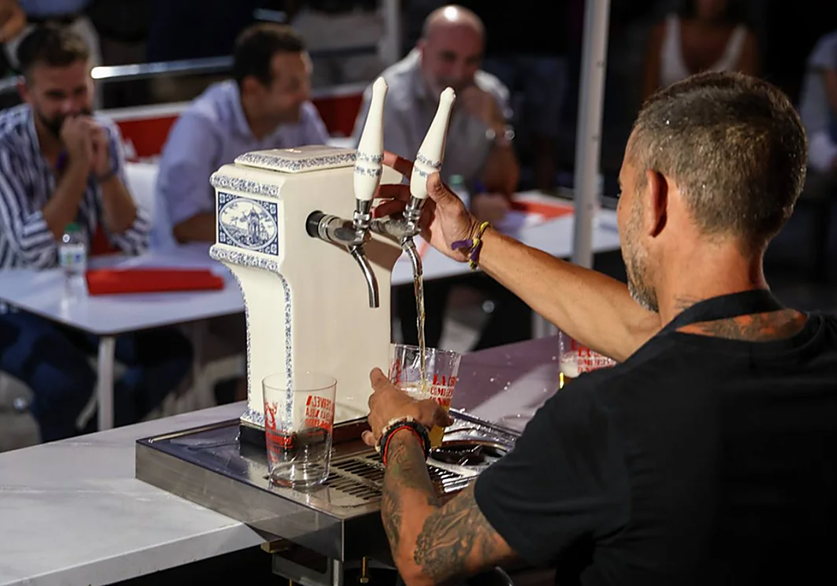 Un participante del concurso de tiradores de cerveza en la Velá de Santa Ana, en Triana
