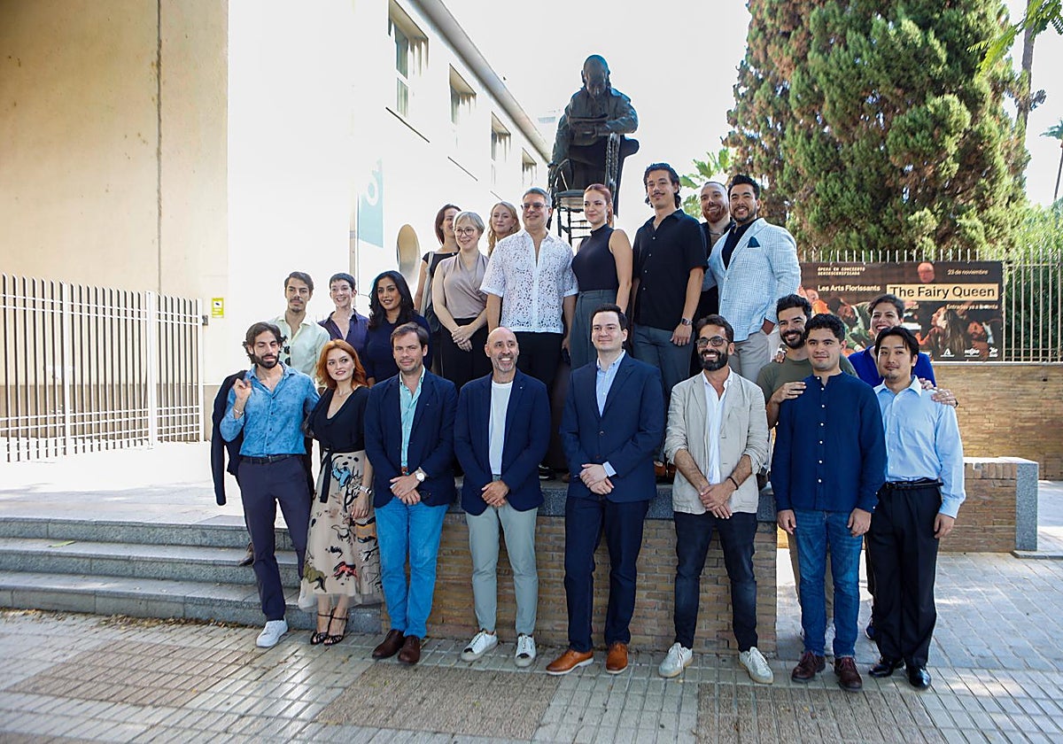 El elenco de la ópera 'Don Giovanni' de Mozart ante la estatua del compositor austríaco, obra de Rolando Campos, a la entrada del teatro de la Maestranza