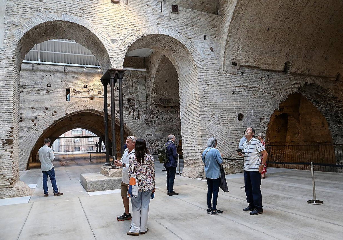 Varios visitantes observando las naves de las Reales Atarazanas de Sevilla