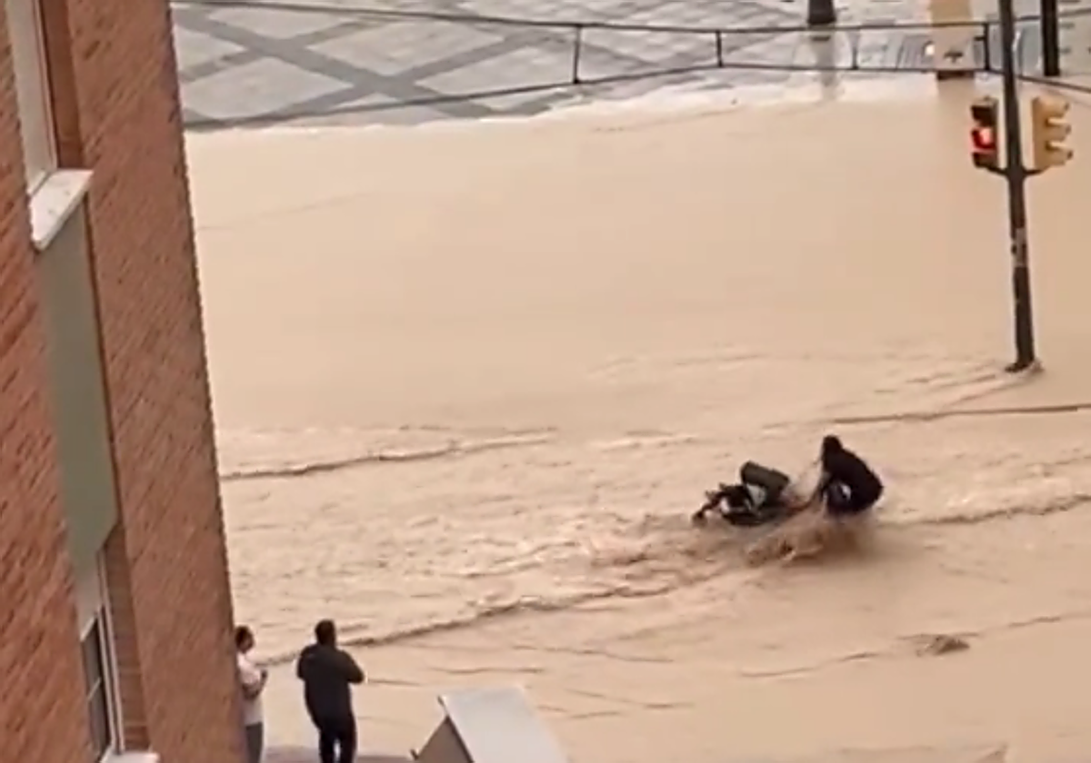 Una mujer trata de cruzar una corriente con un carrito de bebé