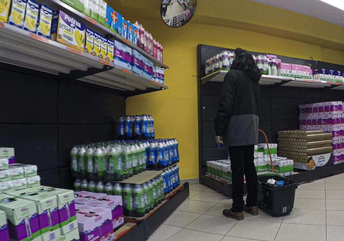 Una mujer, ante la amplia oferta de leche y bebidas vegetales en un supermercado