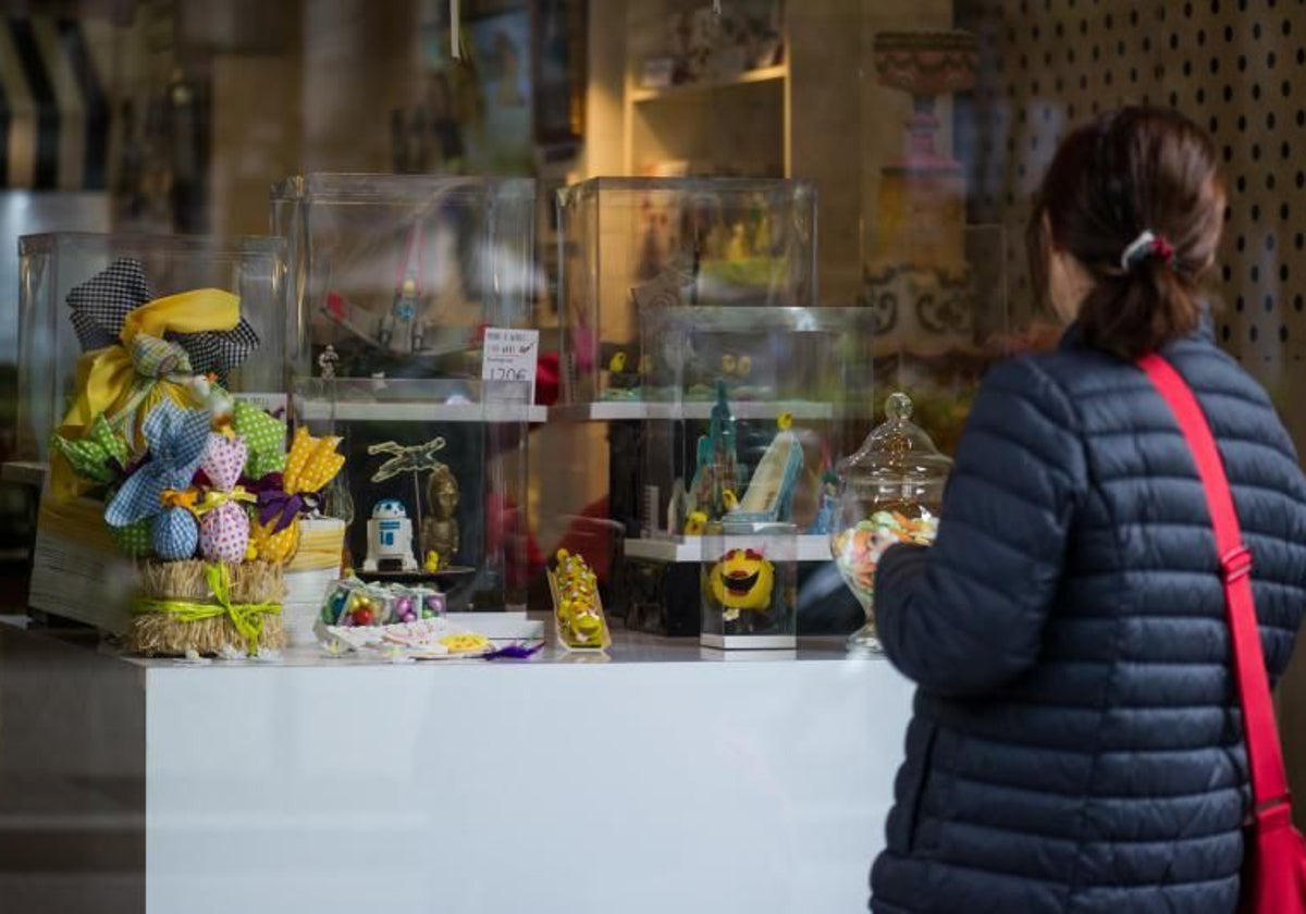 Una señora, mirando monas de Pascua en el escaparate de una pastelería de Barcelona
