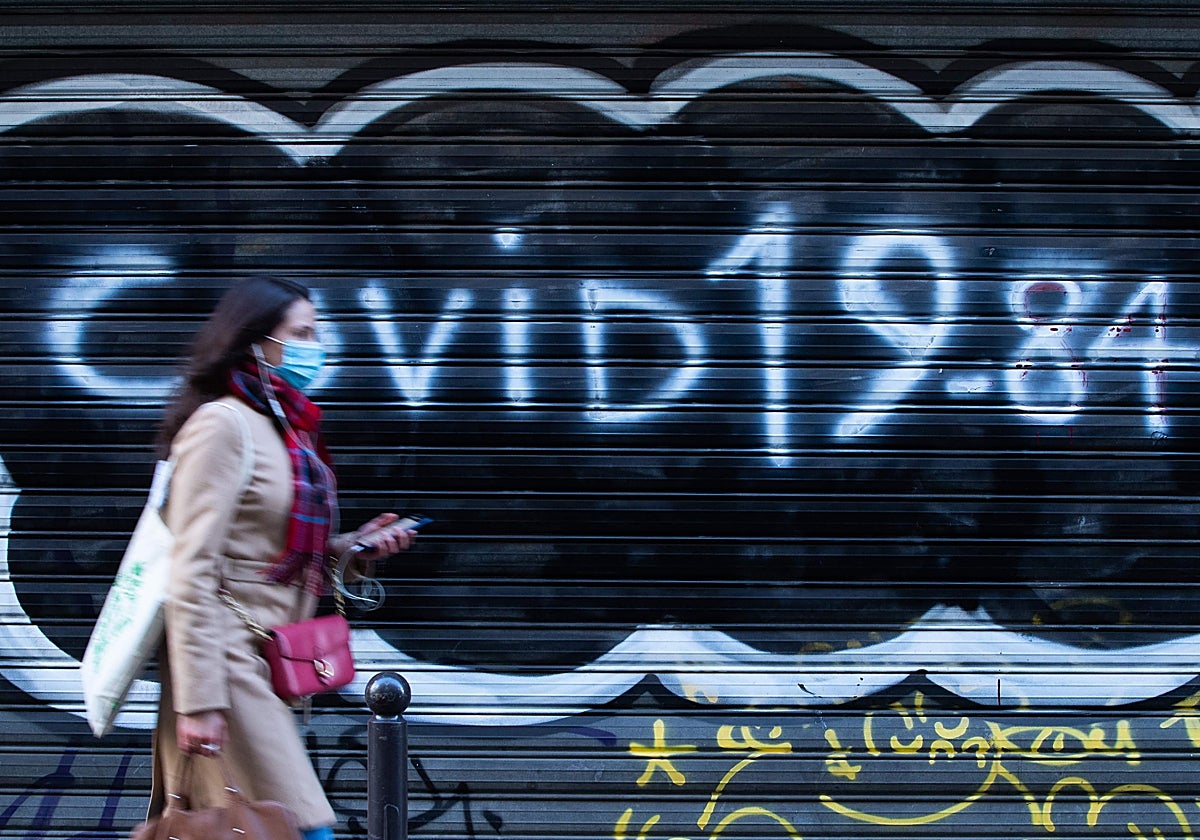 Una mujer pasa sobre una pintada de 'Covid 19_84'