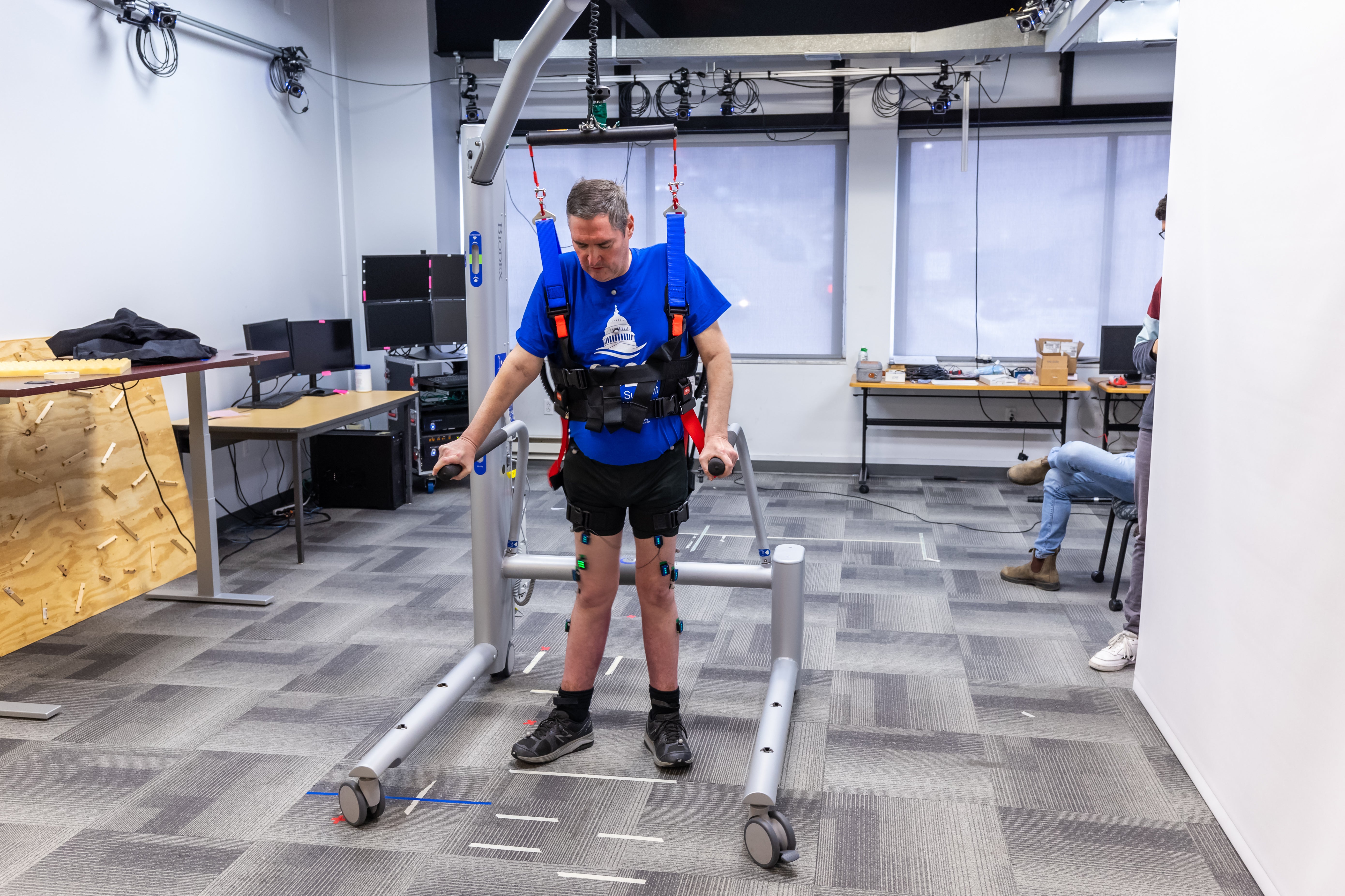 El participante de la investigación Doug McCullough utiliza el sistema de soporte de peso corporal para caminar durante una sesión de prueba en la Universidad de Pittsburgh.
