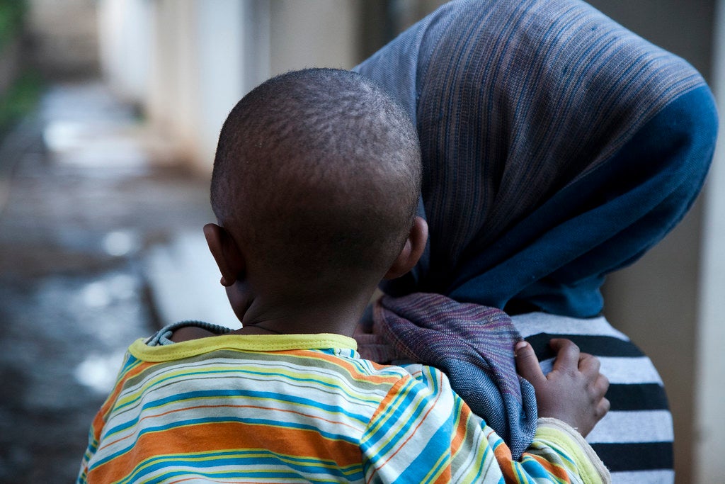 Una madre lleva a su niño en brazos