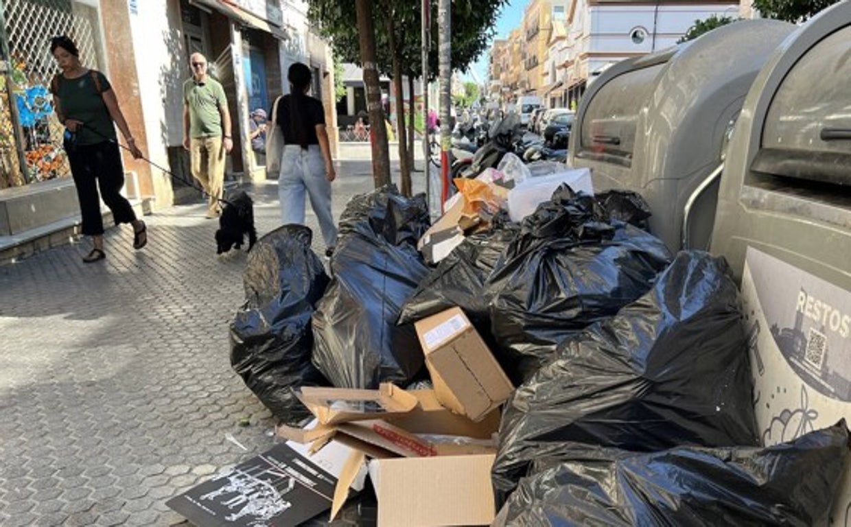 Estado de unos contenedores sin recoger en la calle Feria