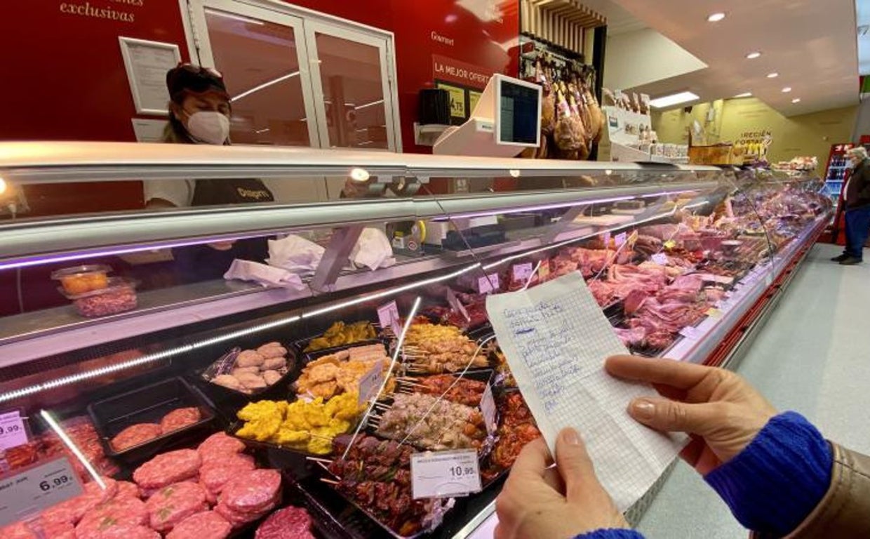 Una cliente con una lista de la compra en un supermercado
