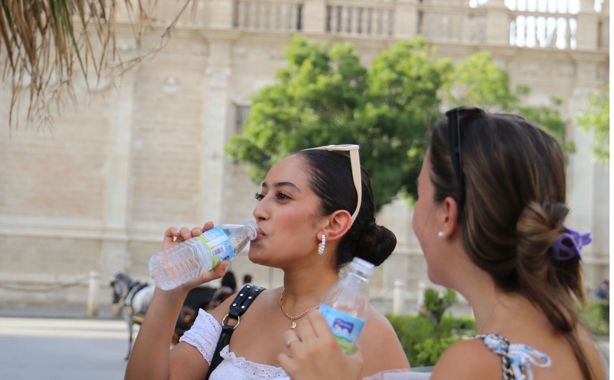 Dos mujeres pasean junto a la Catedral de Sevilla