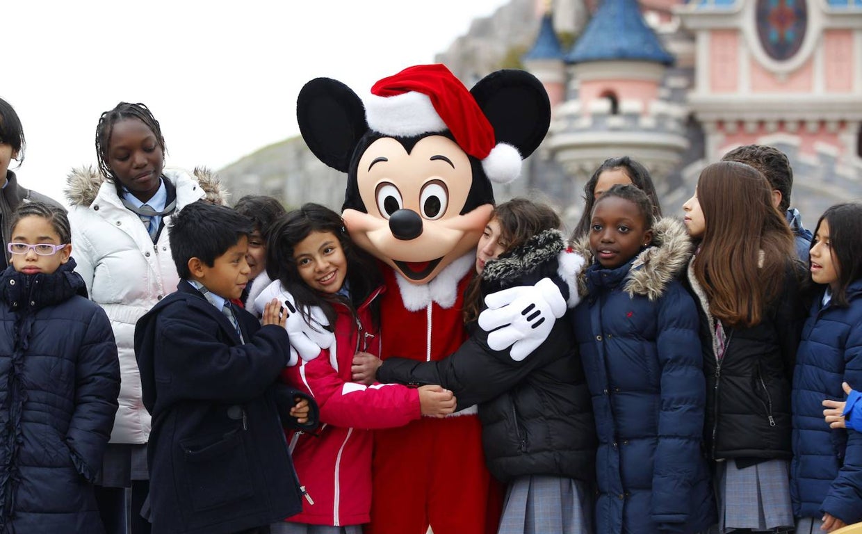 El ratón Mickey abraza a un grupo de niños en Disneyland París