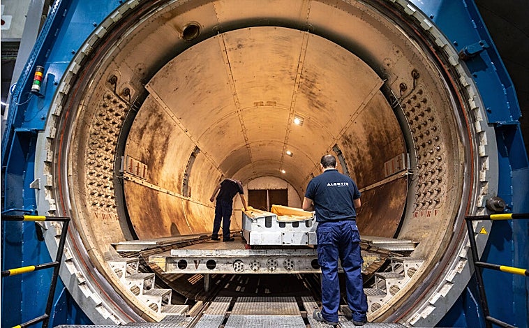 Imagen principal - Arriba, autoclave de la fábrica de Alestis Sevilla, donde se 'curan' las piezas aeronáuticas. Abajo, operario de la empresa aeronáutica en la sala limpia de Alestis y María Eugenia Clemente junto a Manuel González Relaño, director industrial de la compañía