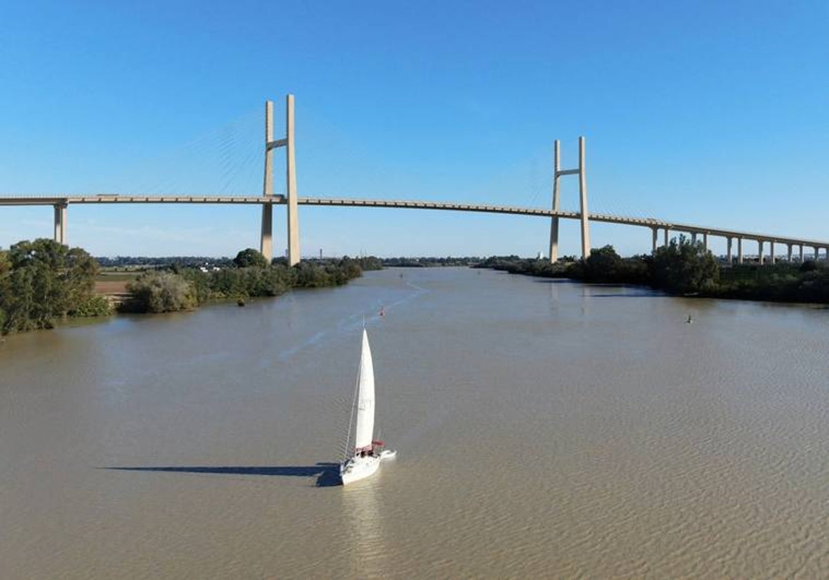 Un barco navega por el río con el puente de la SE-40 en una imagen recreada