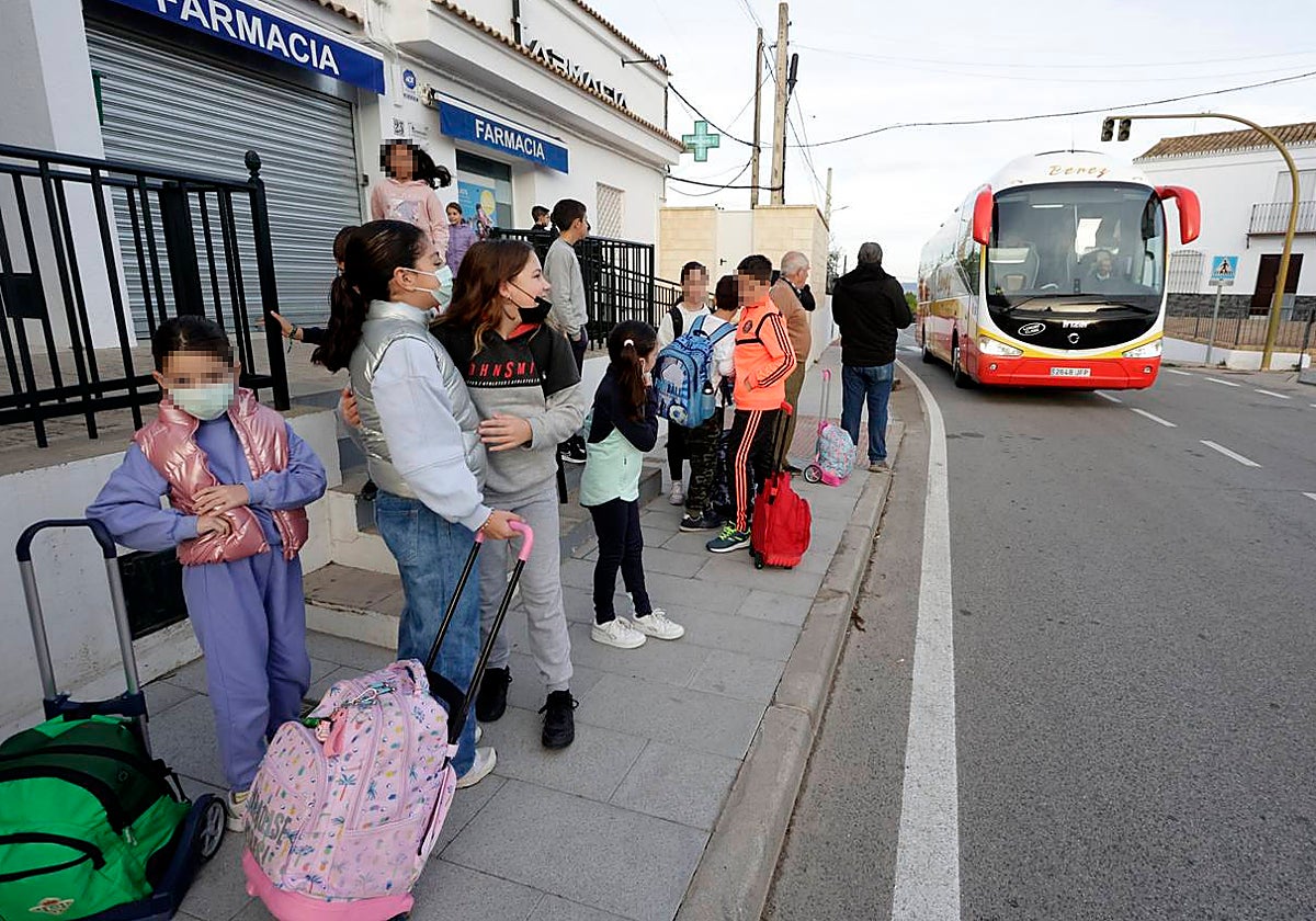 Colas de niños para subir al autobús que los lleva al colegio