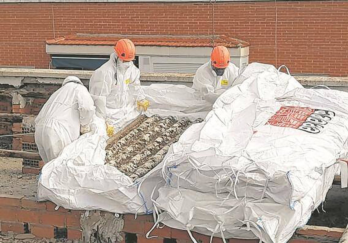 Dos trabajadores retirando uralita