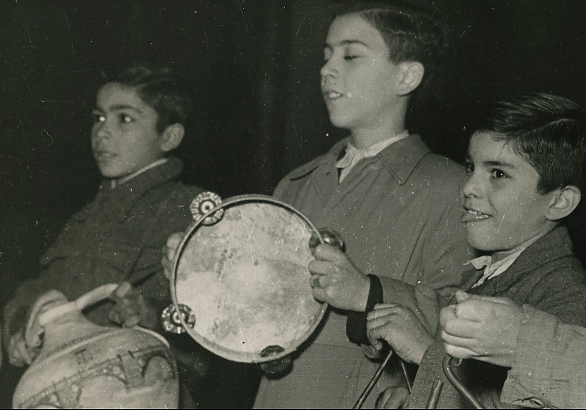 Niños tocando villancicos con cántaro, pandero, triángulos y platillos en 1956