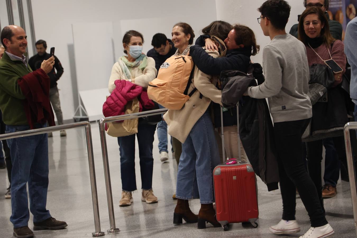 La zona de llegadas del aeropuerto sevillano se llena estos días de unos besos y abrazos muy esperados 