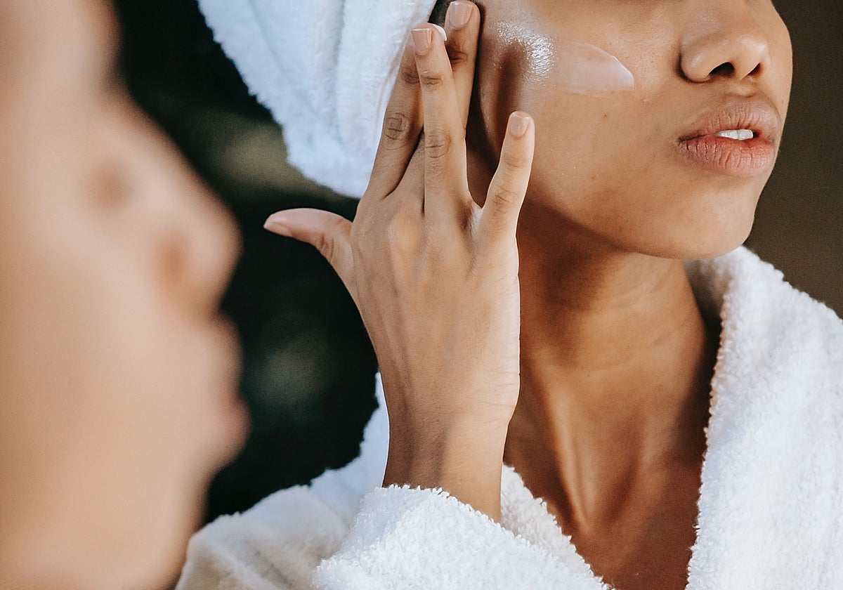 Una joven se aplica una crema hidratante