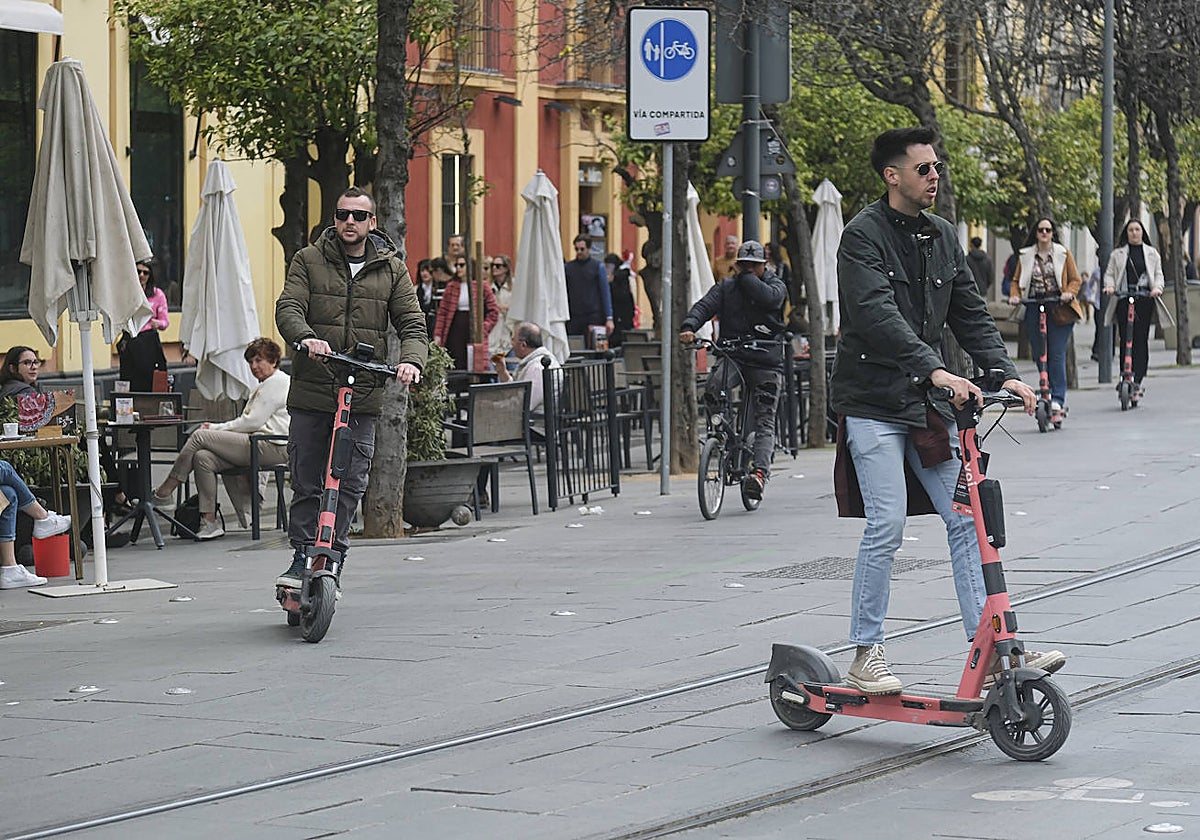 Varios usuarios de patinetes en la calle San Fernando, vía de uso compartido con peatones