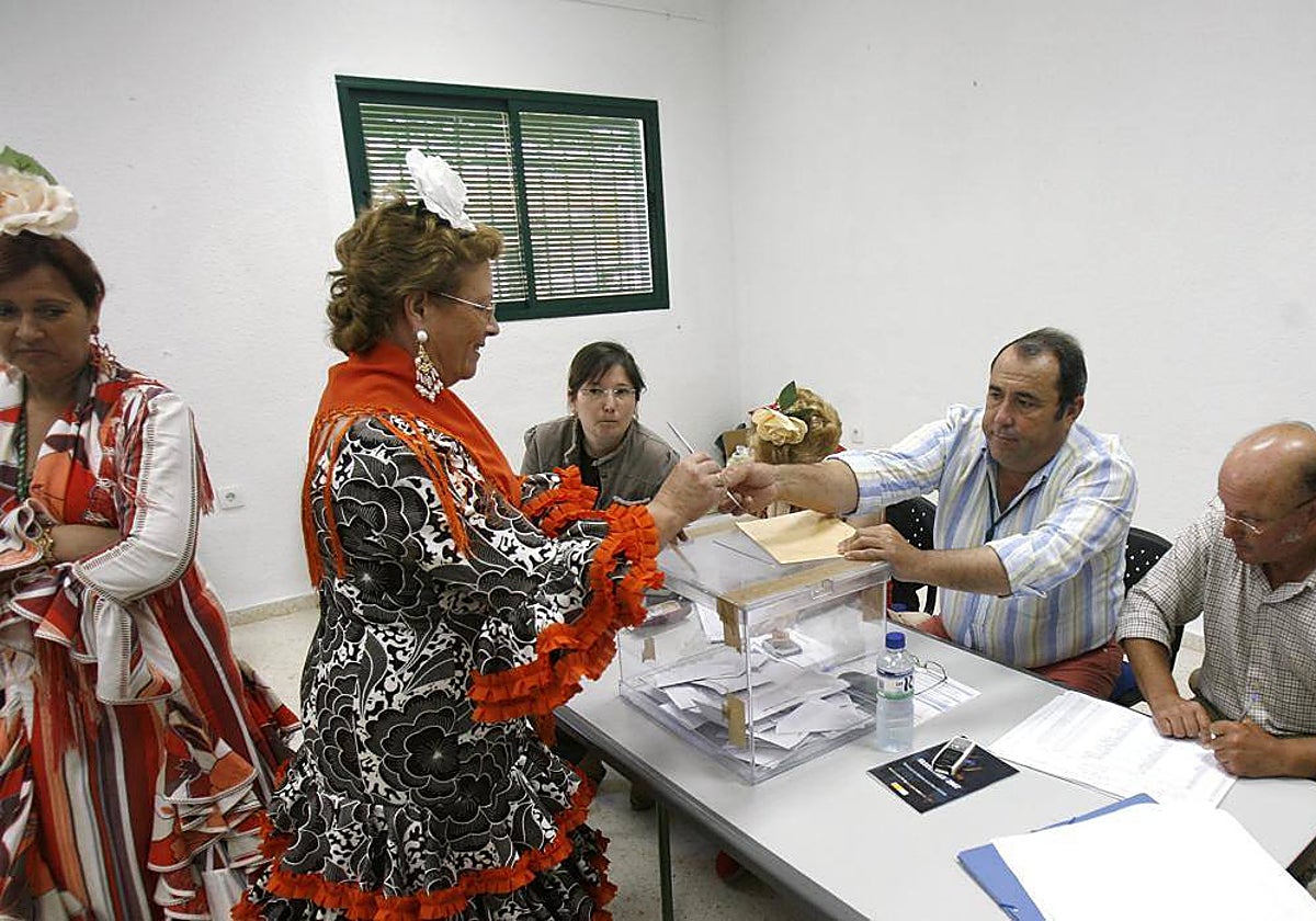 Una mujer, vestida de flamenca, vota en las elecciones municipales de 2015